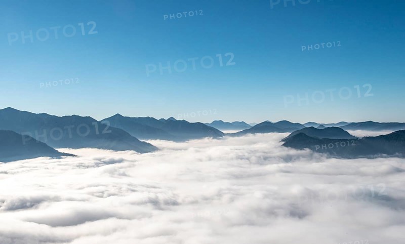 View of mountain peaks with fog over the valley