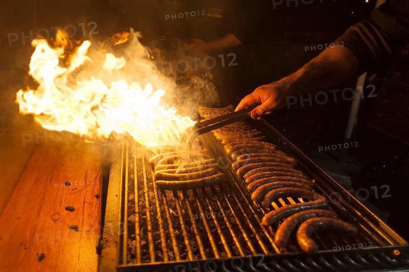 Sausages on a barbecue grill with flames