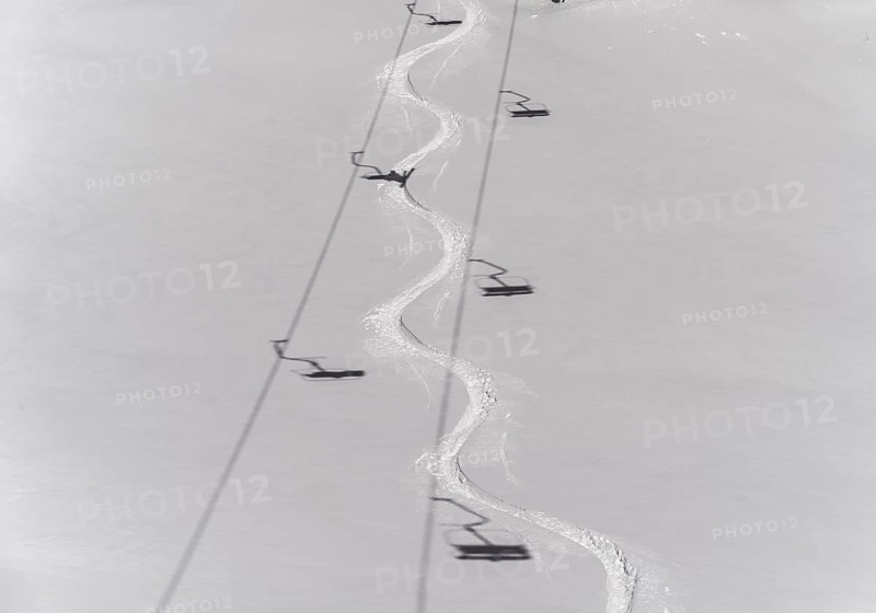 Ski track in deep snow with shadows from a chair lift