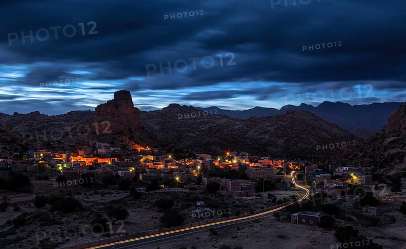 Small village of Aguard Oudad with brightly painted houses in front of the rock Chapeau Napoleon