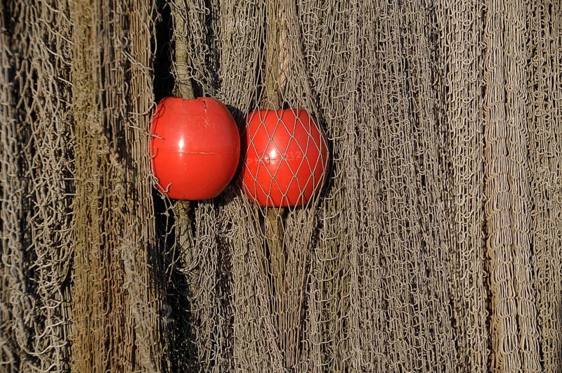 Fishing nets with two red floating buoys