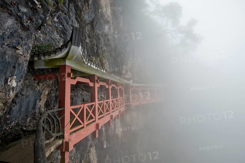 Covered hiking trail on a cliff in fog