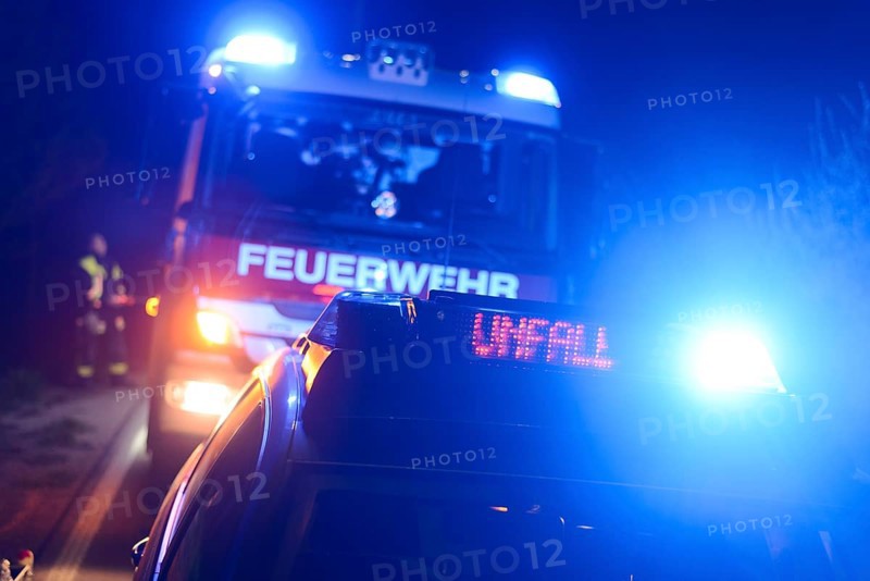 Fire engine and police car with flashing blue lights and the LED display 'Unfall'
