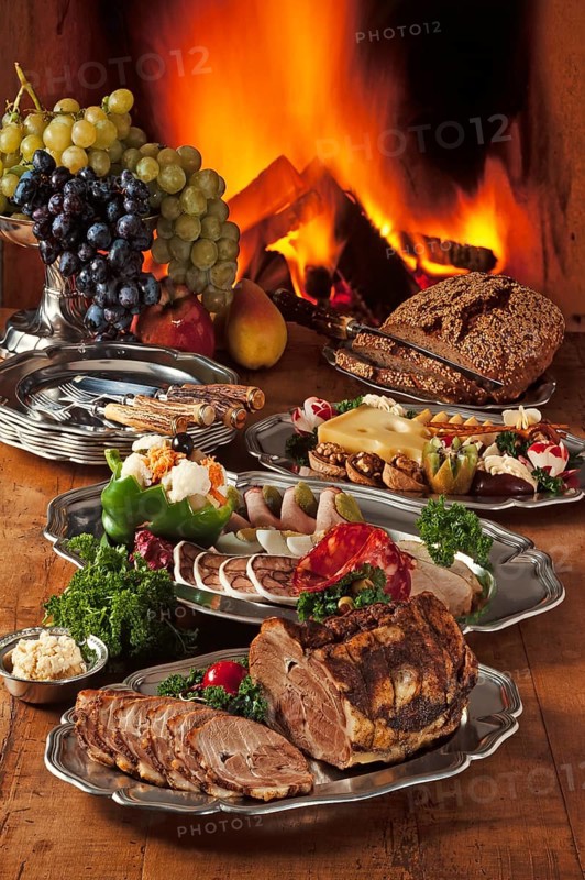 Cold Franconian buffet decorated on pewter in front of a burning fireplace