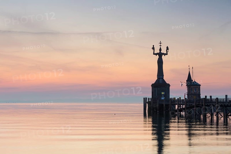 Statue of Imperia at the entrance of the harbour of Konstanz at dawn