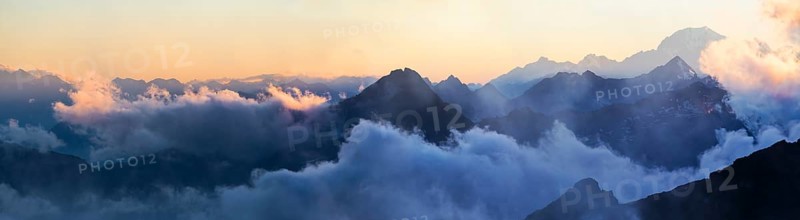 Panorama of the Alps at sunset in the fog
