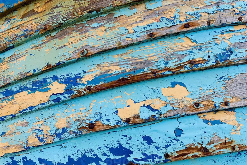 Blue and light blue peeling paint on an old fishing boat