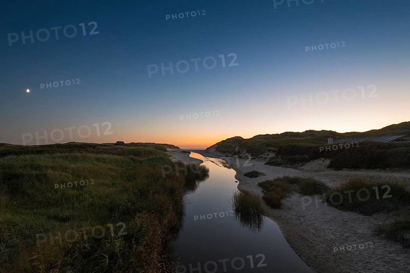 Dune landscape with river Henne Molle A at sunset