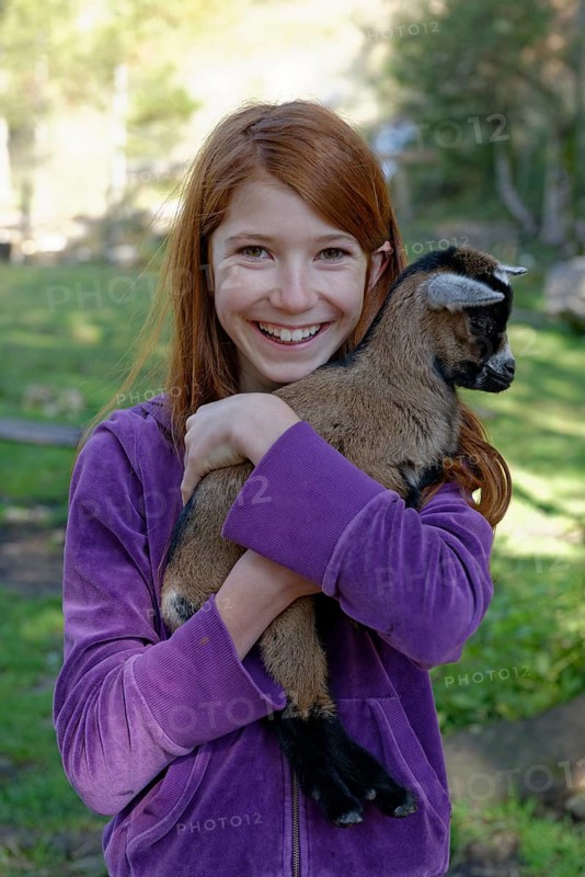 Girl holding a dwarf goat in the petting zoo at Schopperalm