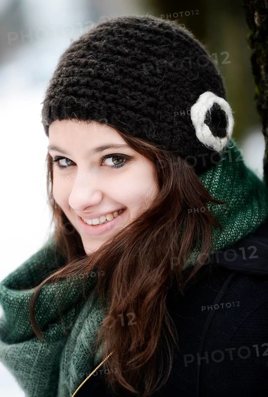 Smiling young woman wearing hat and scarf in winter