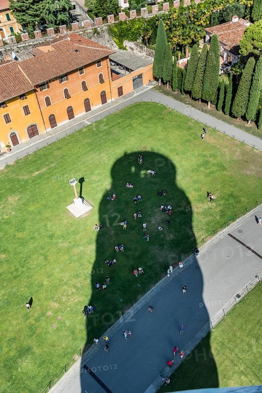 Tourists cooling off in the shade of the Leaning Tower of Pisa