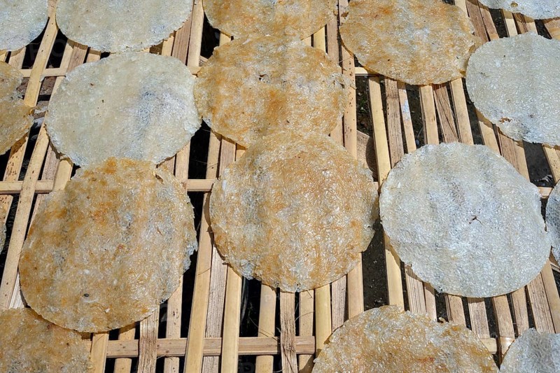 Rice cakes drying on a bamboo frame