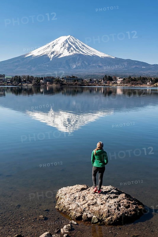Young woman standing on stone in water