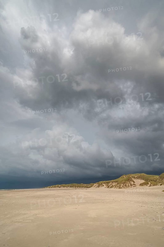 Dramatic storm clouds over beach and dunes