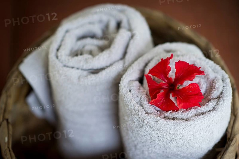Two rolled white towels in a basket