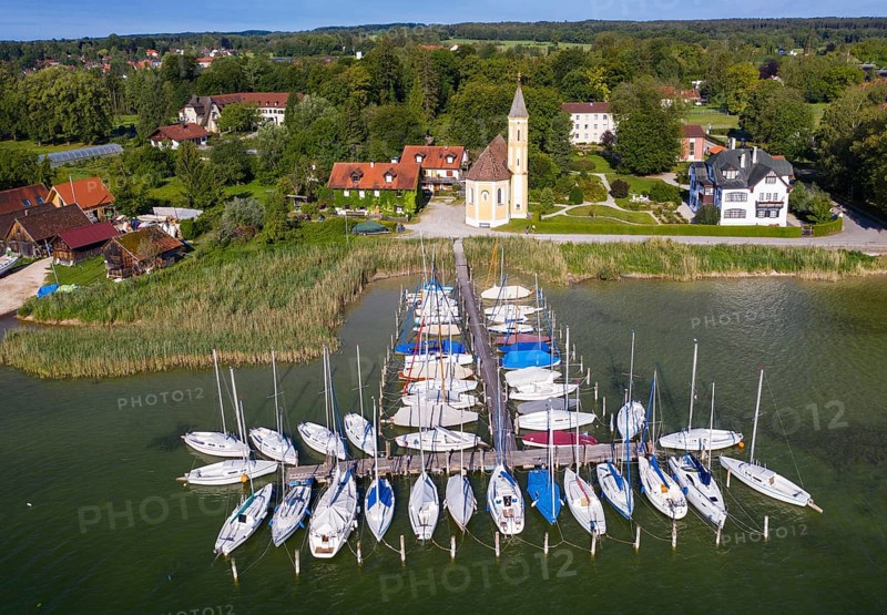 Boat landing stage in the Lake Ammer and church St. Alban