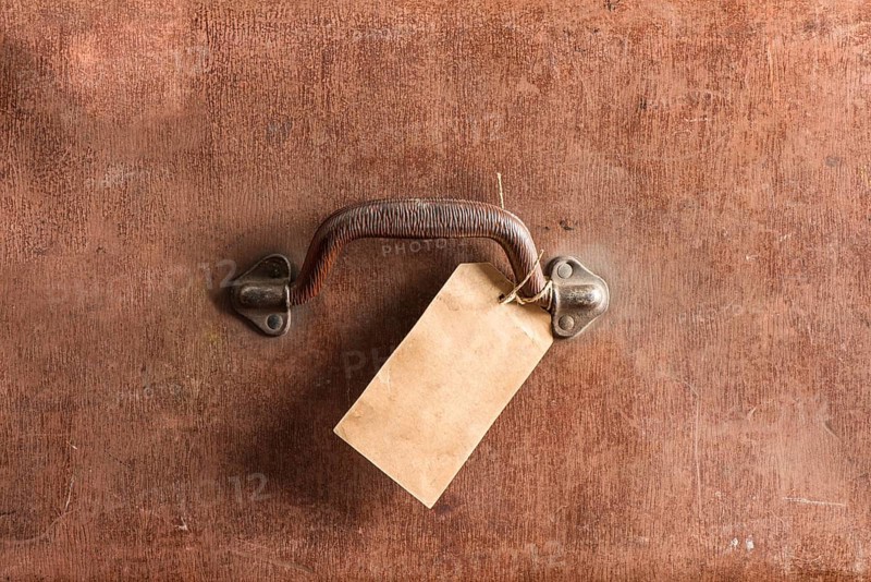 Handle and luggage tag of an old brown leather bag