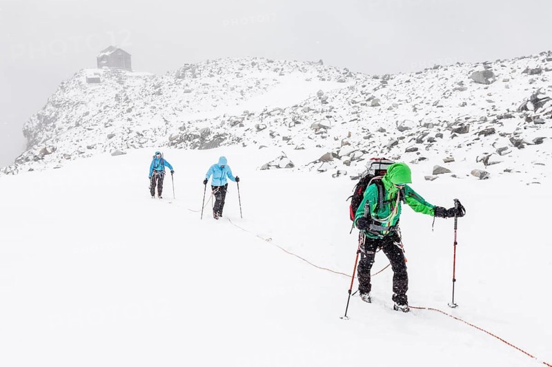 Rope team in a storm during the ascent of Mt Schwarzenstein via the glacier