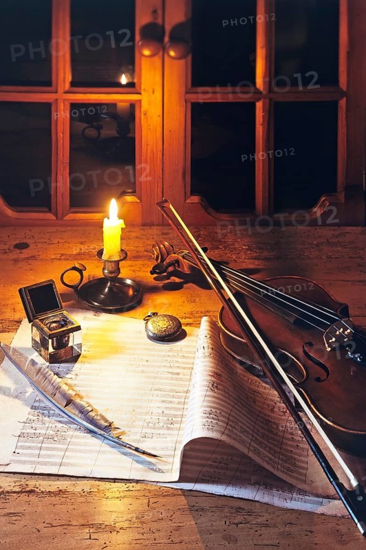 Violin on a music sheet with inkwell and quill