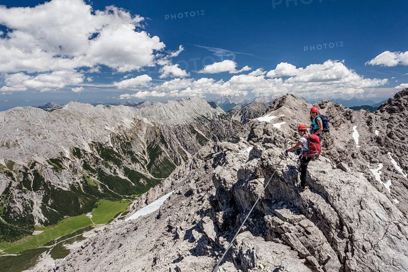 Hikers on the summit ridge during the ascent through the Imster via ferrata on the Maldonkopf in the Lech Valley Alps
