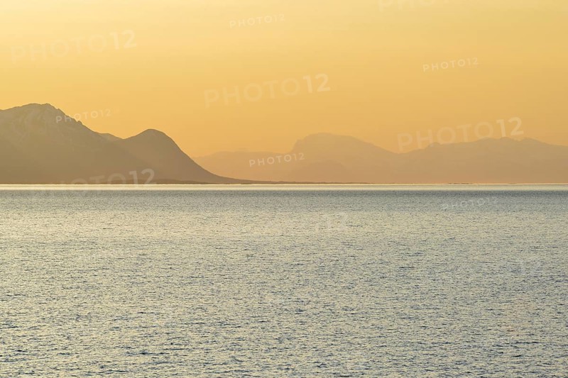Sunset in the fjord with mountains in the mist