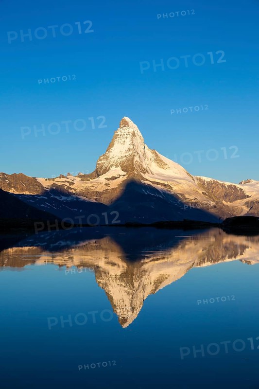 First sunlight on the Matterhorn with reflection in Stellisee lake