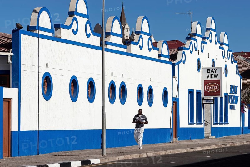 Local man walking in front of a colonial building