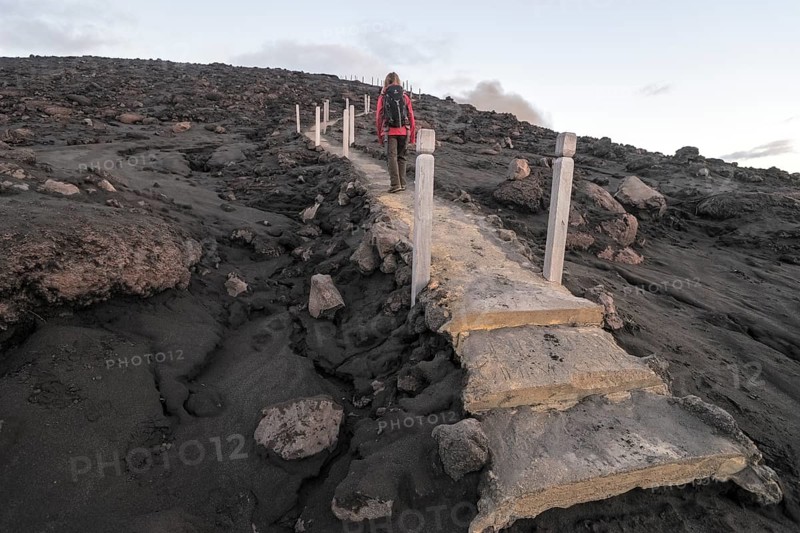 Woman climbing stairs to the crater of Mount Yasur volcano