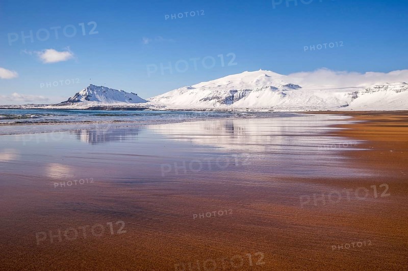 Sunny winter day on the sandy beach in front of Snaefellsjokull volcano