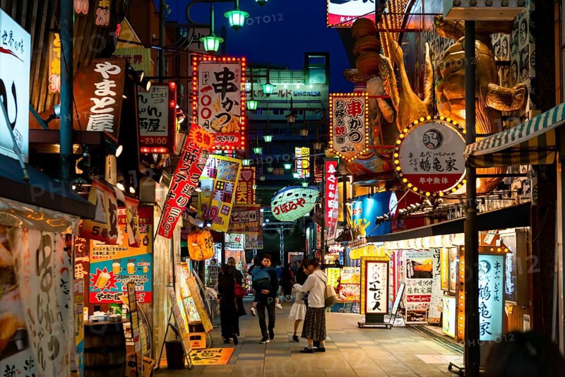 Many colorful neon signs in a pedestrian zone with shops and restaurants