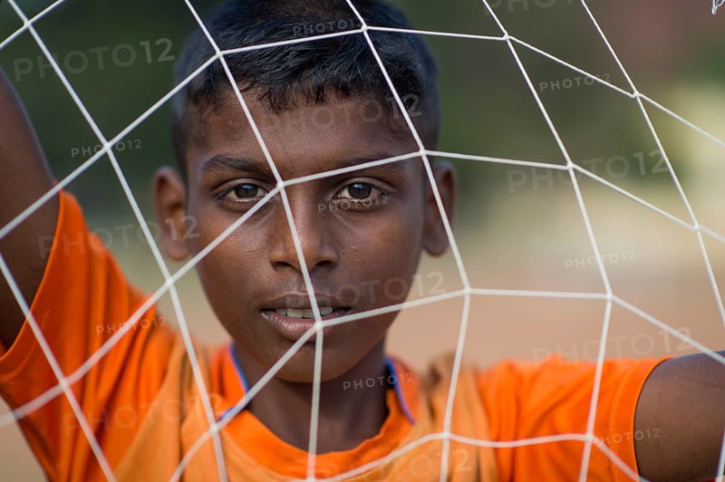 Boy looking through goal net