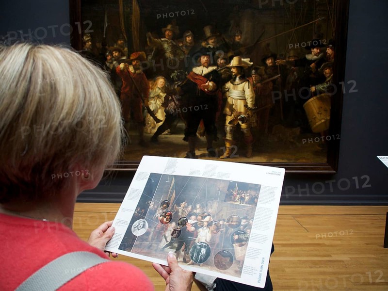 Visitor watching the painting The Night Watch by Rembrandt at the Rijksmuseum