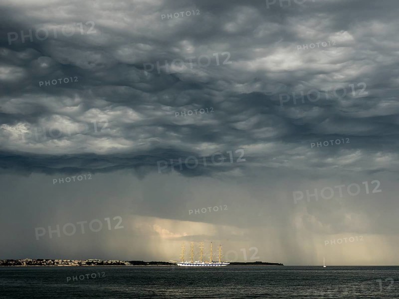 Five-master sailing ship in front of Crveni Vrh in thunderstorm atmosphere seen from Piran