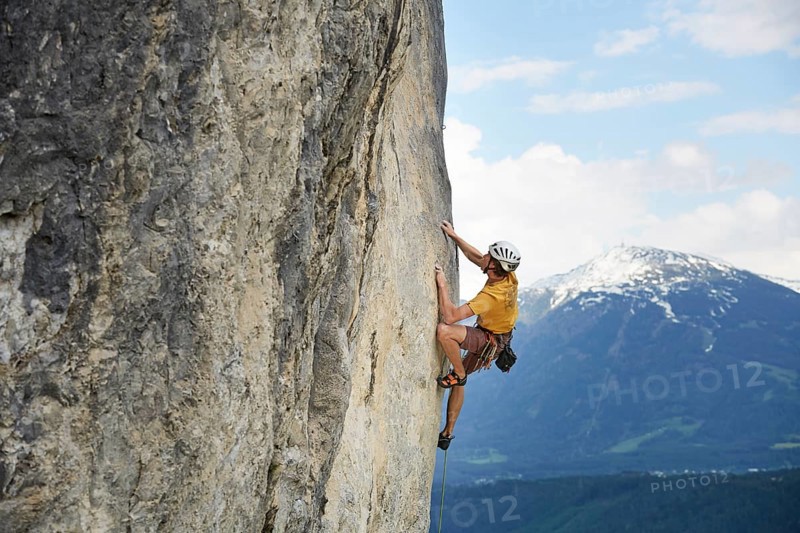 Freeclimber with helmet climbing on a rock face
