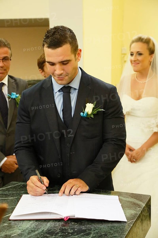 Groom signing the church register after the ceremony