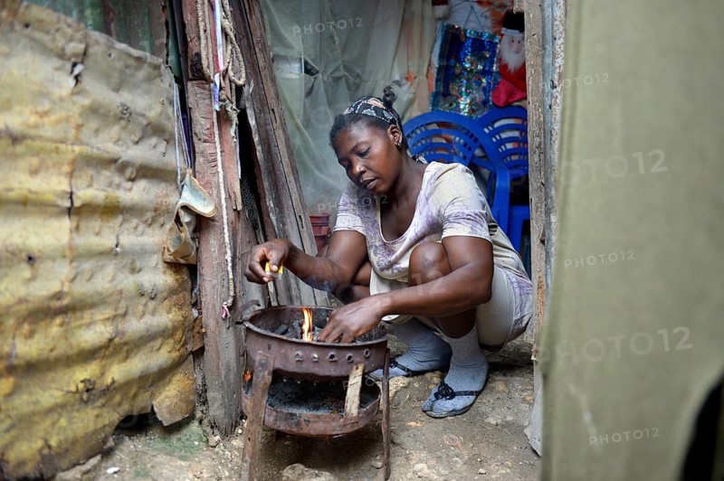 Woman cooking in the improvised kitchen of an ramshackle hut