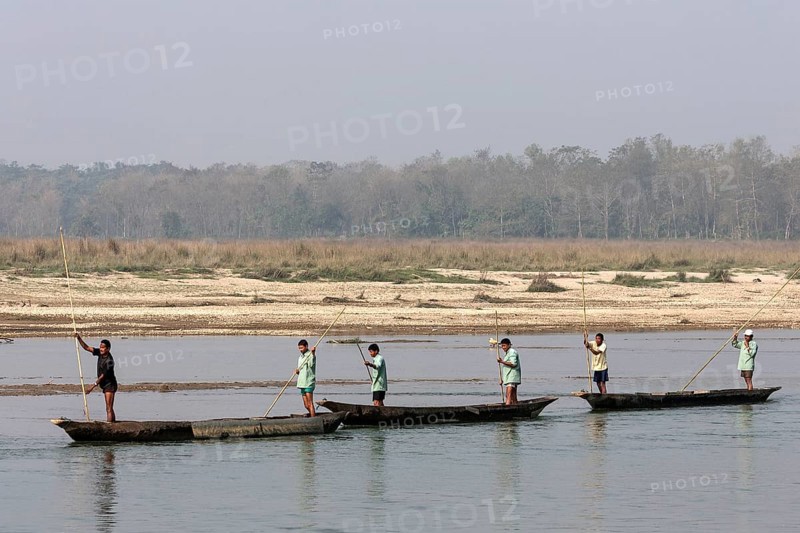 Nepalese men in dugouts on the East Rapti River at Sauraha