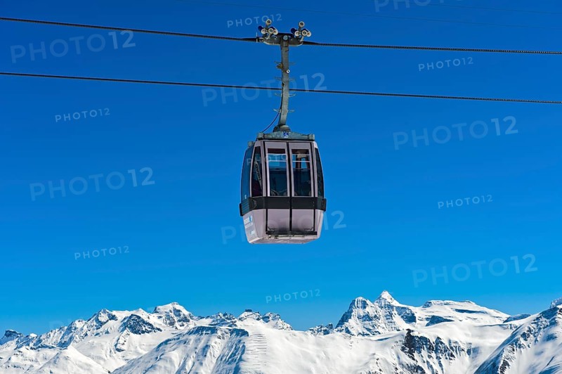 Gondola of the Moosfluh cable car in front of the snowy mountain range of the Valais Alps