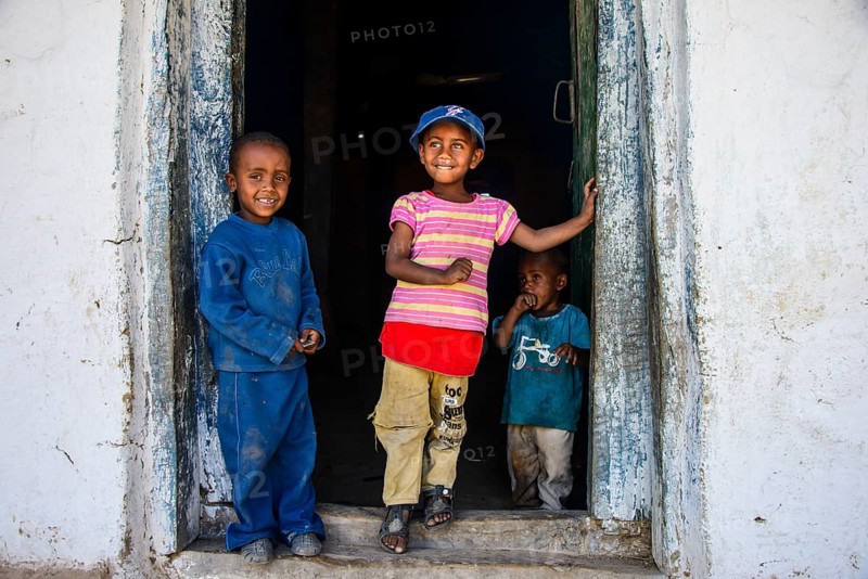 Young children standing in a door frame