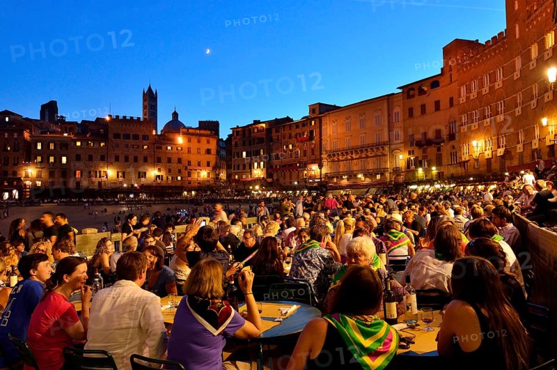 Crowded tables of the restaurants on the track of the Palio di Siena after the race