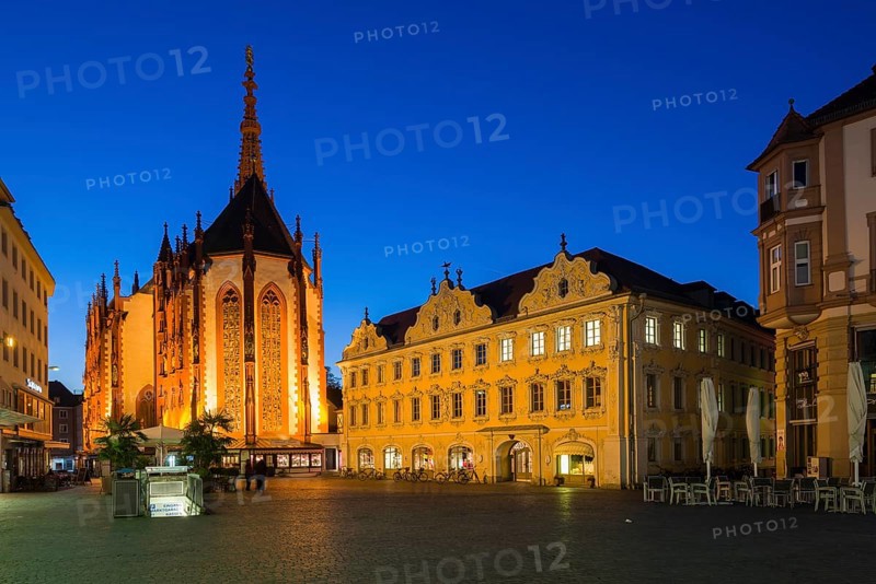 The illuminated Falkenhaus building and the Marienkapelle church