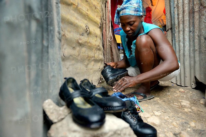 Woman shining the shoes of her children for their first day of school