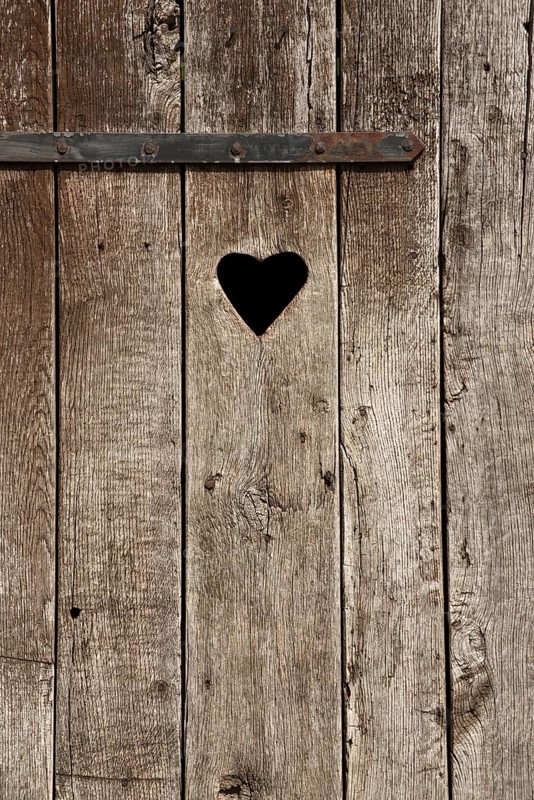 Weathered wooden door with a heart