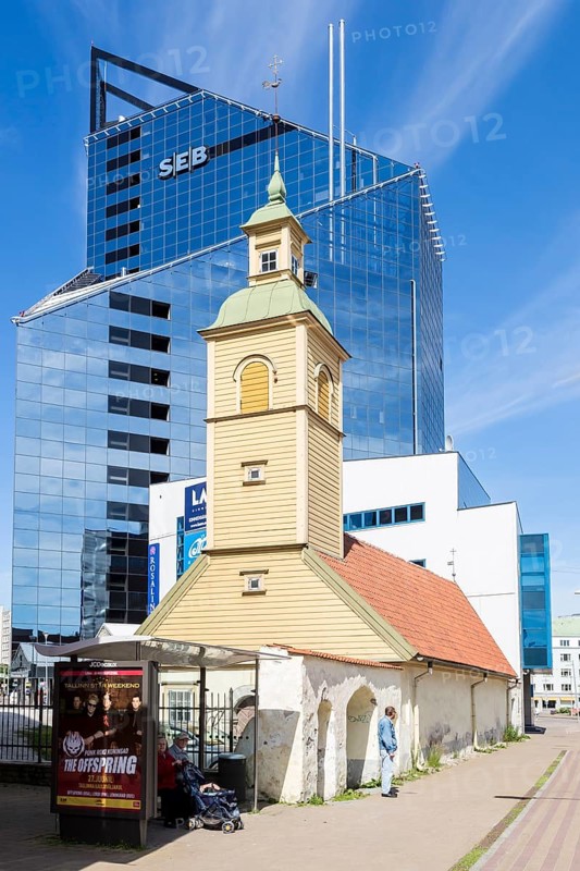 Wooden church in front of modern building of SEB bank in the financial and business district