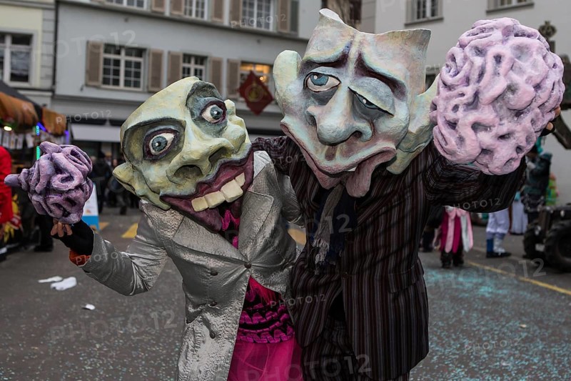 Pair wearing masks holding a brain