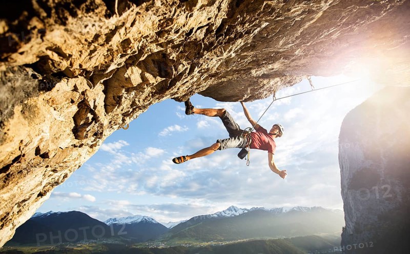 Freeclimber with helmet climbing on a rock face