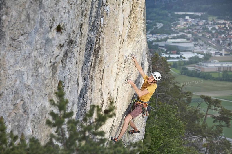 Freeclimber with helmet climbing on a rock face