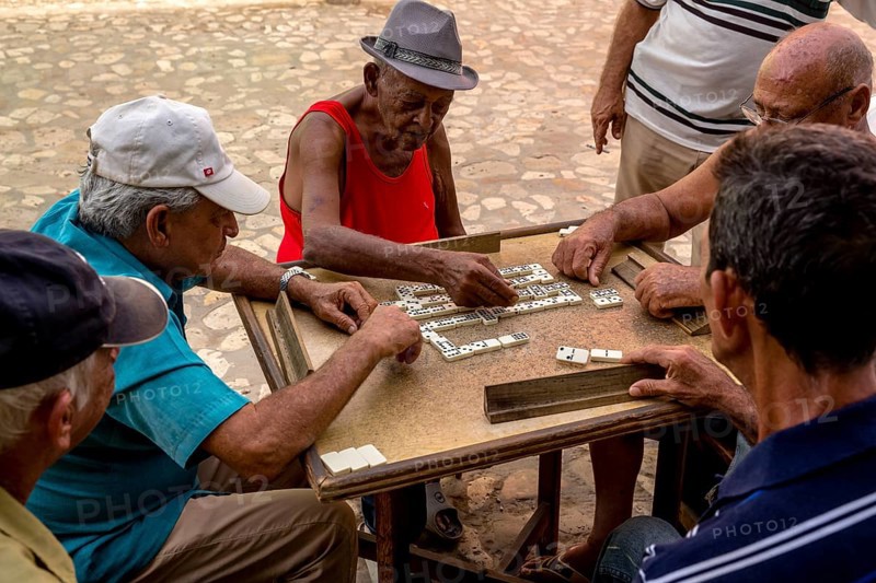 Cuban men playing dominoes at a table outside