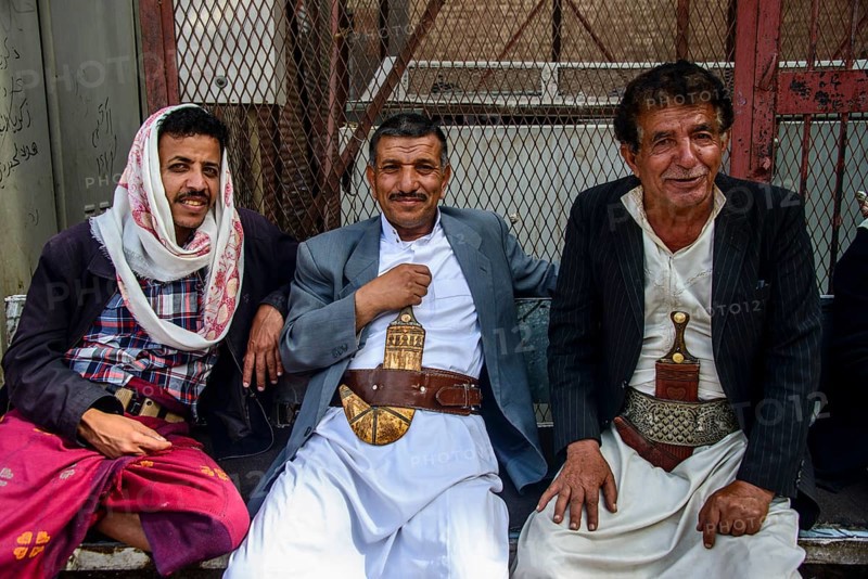 Men with their djambias sitting in front of a house in the old city