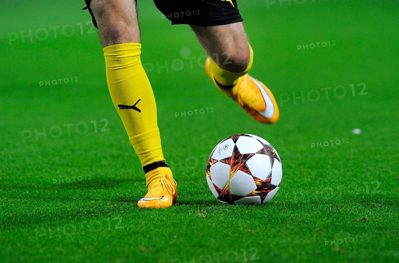 Legs of a BVB player with adidas Champions League Ball